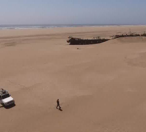 Homme_sort_du_pickup_et_approche_une_epave_echouee_dans_le_desert_2