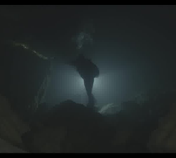 Silhouette_of_a_diver_with_a_flashlight_exploring_a_dark_underwater_cave_160930T7