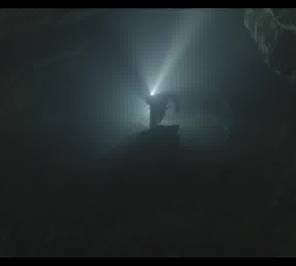 Silhouette_of_a_diver_with_a_flashlight_swimming_in_a_dark_underwater_cave_160930ZS